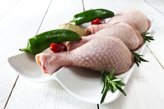 Fresh - raw chicken drumsticks on the plate