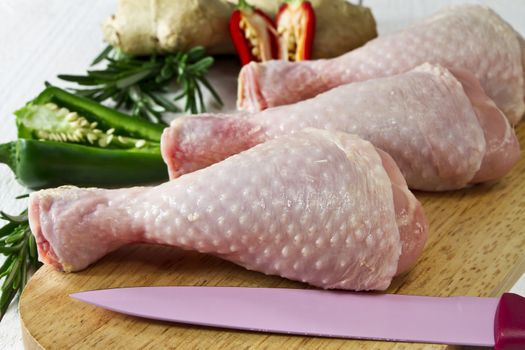 Fresh - raw chicken drumsticks on chopping board