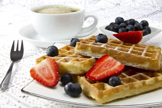 Freshly baked waffles with berries and coffee