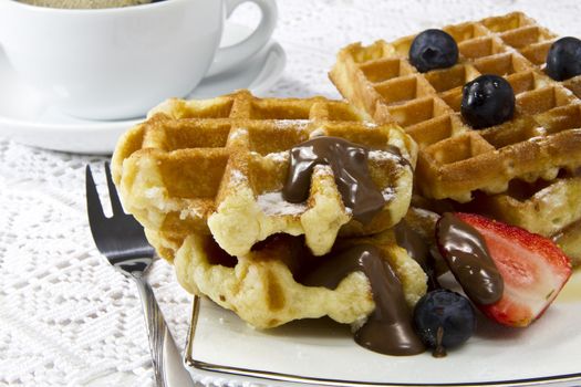 Freshly baked waffles with berries and coffee