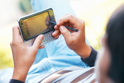 Male hand with digitized pen, touching the screen of a PDA.