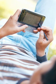 Male hand with digitized pen, touching the screen of a PDA outdoors