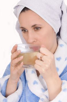 Happy woman in bathrobe drinking cup tea
