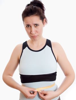 attractive woman measuring her waist measuring tape and the testimony of upset isolated