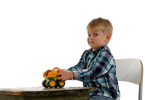 Little Boy Sits on Chair, Plays with his Toy Car and Says "It's Mine" on white background