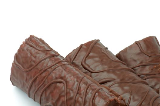 Delicious Biscuit Swiss Rolls  with Decorated Chocolate Glaze closeup on white background