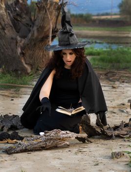 Witch conjures spells vychityvaya pronouncing them in a book
