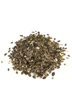 Pile of whole fresh pumpkin seeds in the husk used as an ingredient in cooking, as a delicious roast snack, or to produce sunflower oil