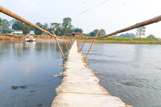 Handmade bamboo wooden sand bag bridge in Chitwan Nepal