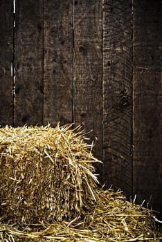 Bale of straw and dark wooden background with vignette