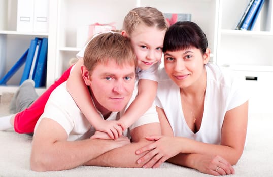Portrait of happy family lying together, hugging and happy