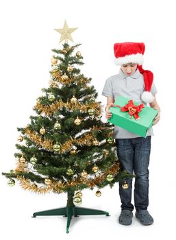 surprised boy in santa hat with christmas present on white background