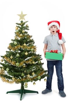 surprised boy in santa hat with christmas present on white background
