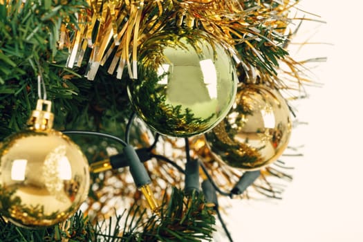 Decorated christmas tree with yellow and green balls on white background