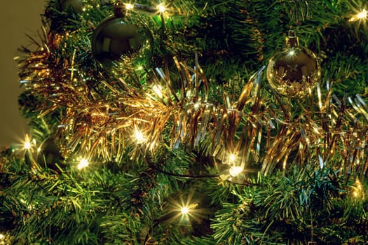 glowing lights on a Christmas tree with yellow and green balls 