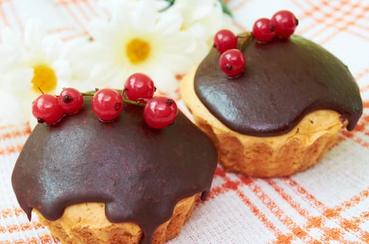 Cakes  covered with chocolate glaze and decorated with berries