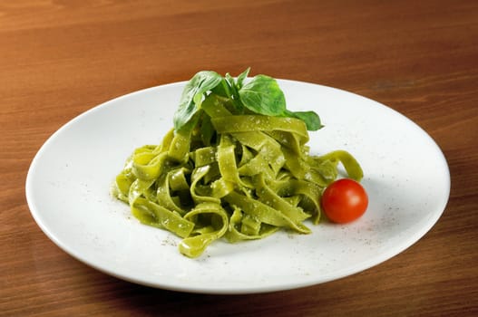 Tagliatelle pasta with pesto on light plate. closeup