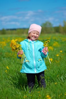 small girl  on meadow with dandelion