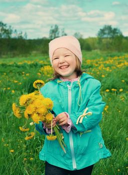 small girl  on meadow with dandelion