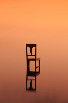 The restless chair in the pond at sunset