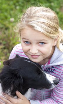Girl looking at camera, hugging a dog