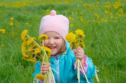 small girl  on meadow with dandelion