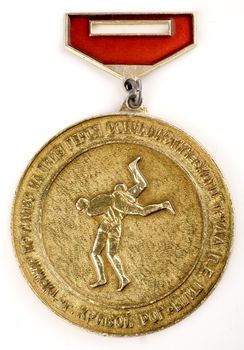 Sports medal in sambo reading "sambo tournament for the prize of the Hero of Socialist Labor P.E.Gil in Krivoy Rog" on a white background