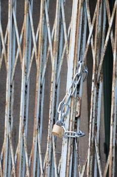 Closed padlock with a chain on a metallic grid