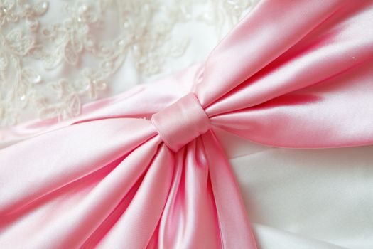  close up of a wedding dress with a large silk bow
