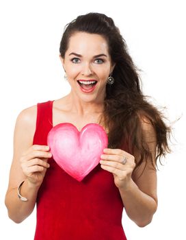 A beautiful happy woman looking surprised and holding a red love heart. Isolated on white.