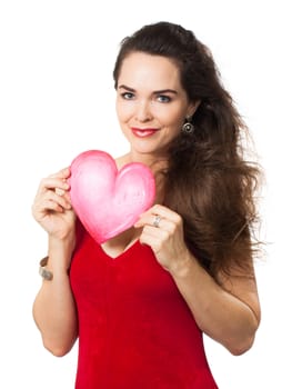 A beautiful young woman in a red dress holding a red love heart. Isolated on white.