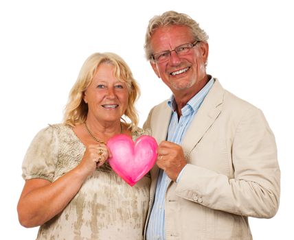 A happy middle aged couple holding a love heart and smiling,. Isolated on white.