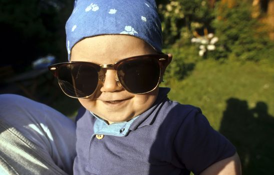 boy with huge sunglasses in the garden