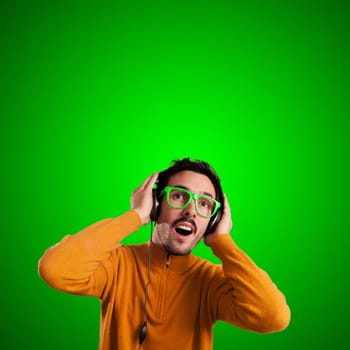 guy with headphones listening to music on green background