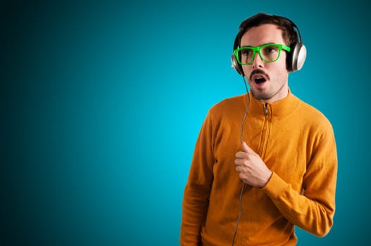 guy with headphones listening to music on green background