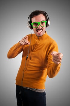 guy with headphones listening to music on green background