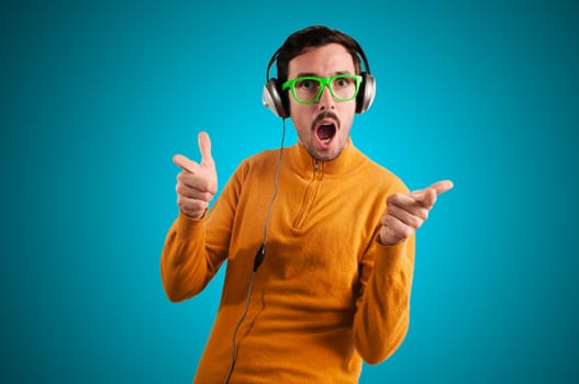 guy with headphones listening to music on green background