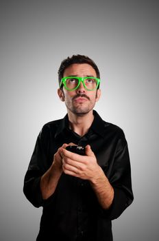 thinking man holding phone on gray background