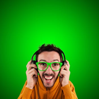 guy with headphones listening to music on green background