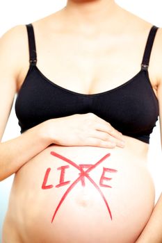The word LIFE in red capital letters crossed through and cancelled handwritten on the bare swollen belly of a pregnant woman