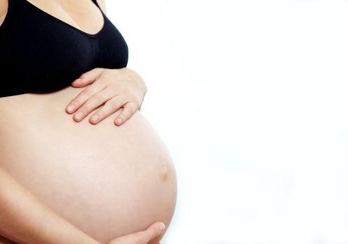 Cropped portrait of a pregnant woman bonding with her chlid holding her swollen abdomen in a nurturing caring manner isolated on white