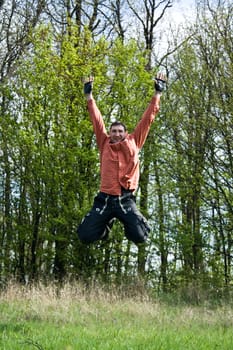 happy man on meadow jumping in the air