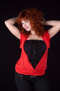 Portrait of beautiful redhead girl on black background