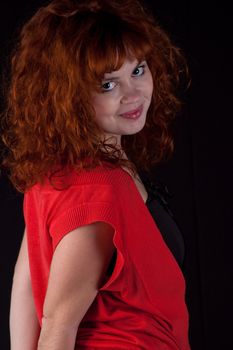 Portrait of beautiful redhead girl on black background