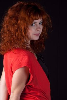 Portrait of beautiful redhead girl on black background