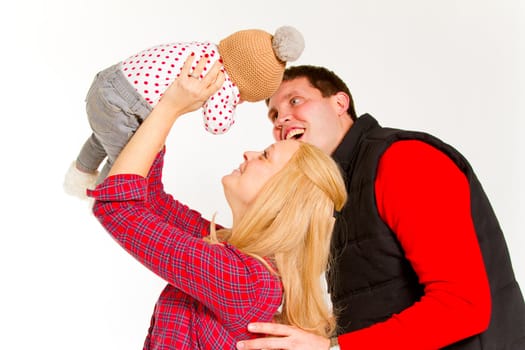 A family portrait of three people in the studio including mother father and newborn baby girl.