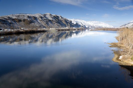 Columbia River Flows After Fresh Snow beneath Mountain Peaks and Businesses