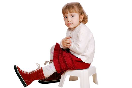 Beauty little girl sitting on a chair studio shot