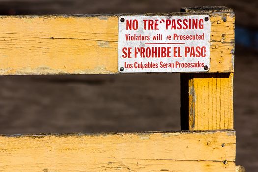 Worn No Tresspassing, Violators will be Prosecuted in English and Spanish