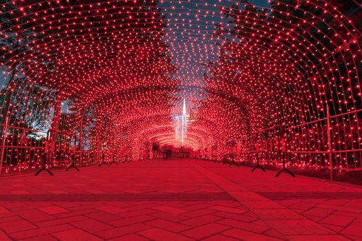 Road with neon light arch overhead at night